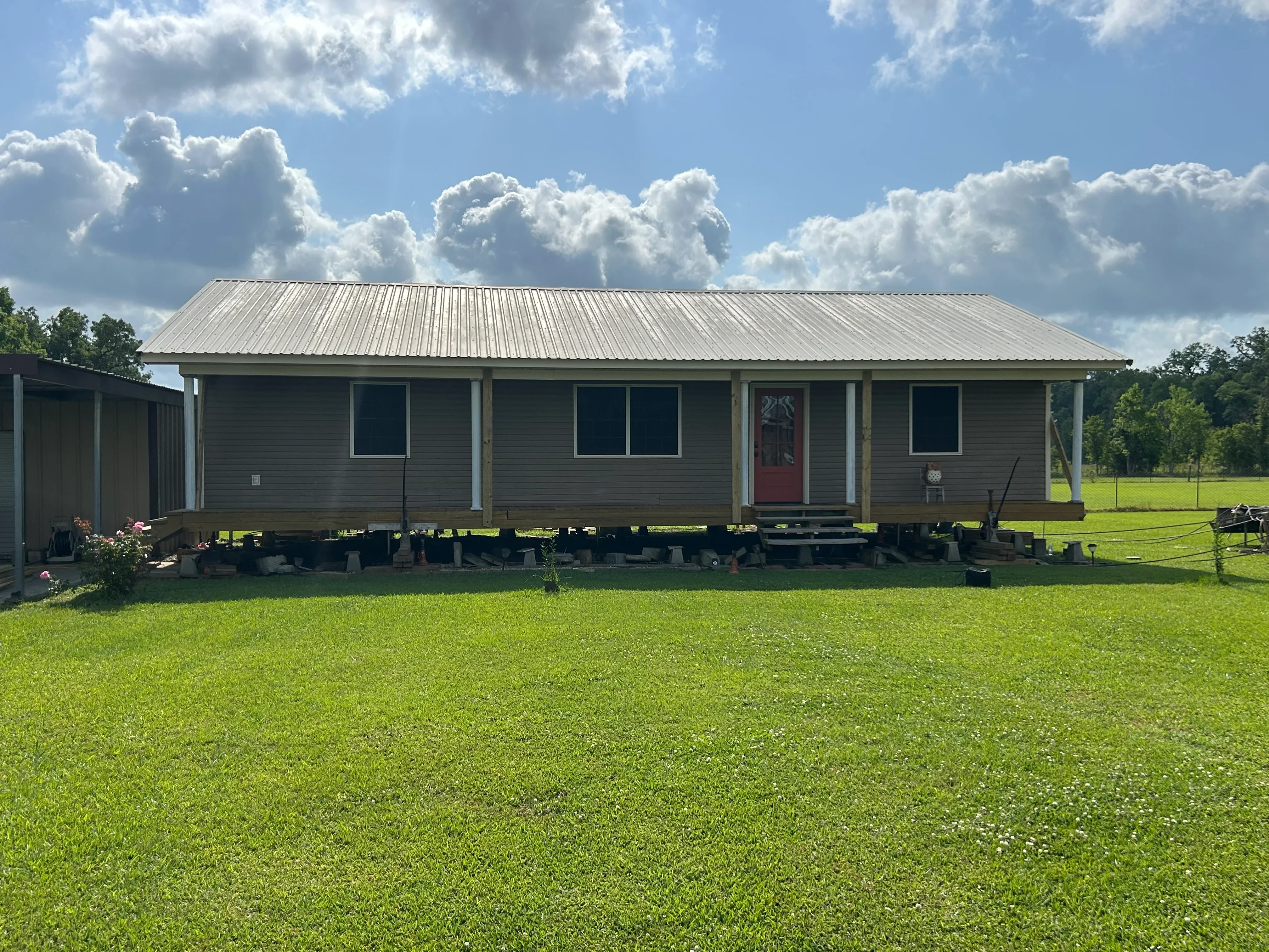 Mobile home elevated on concrete block and pier foundation supports in rural setting