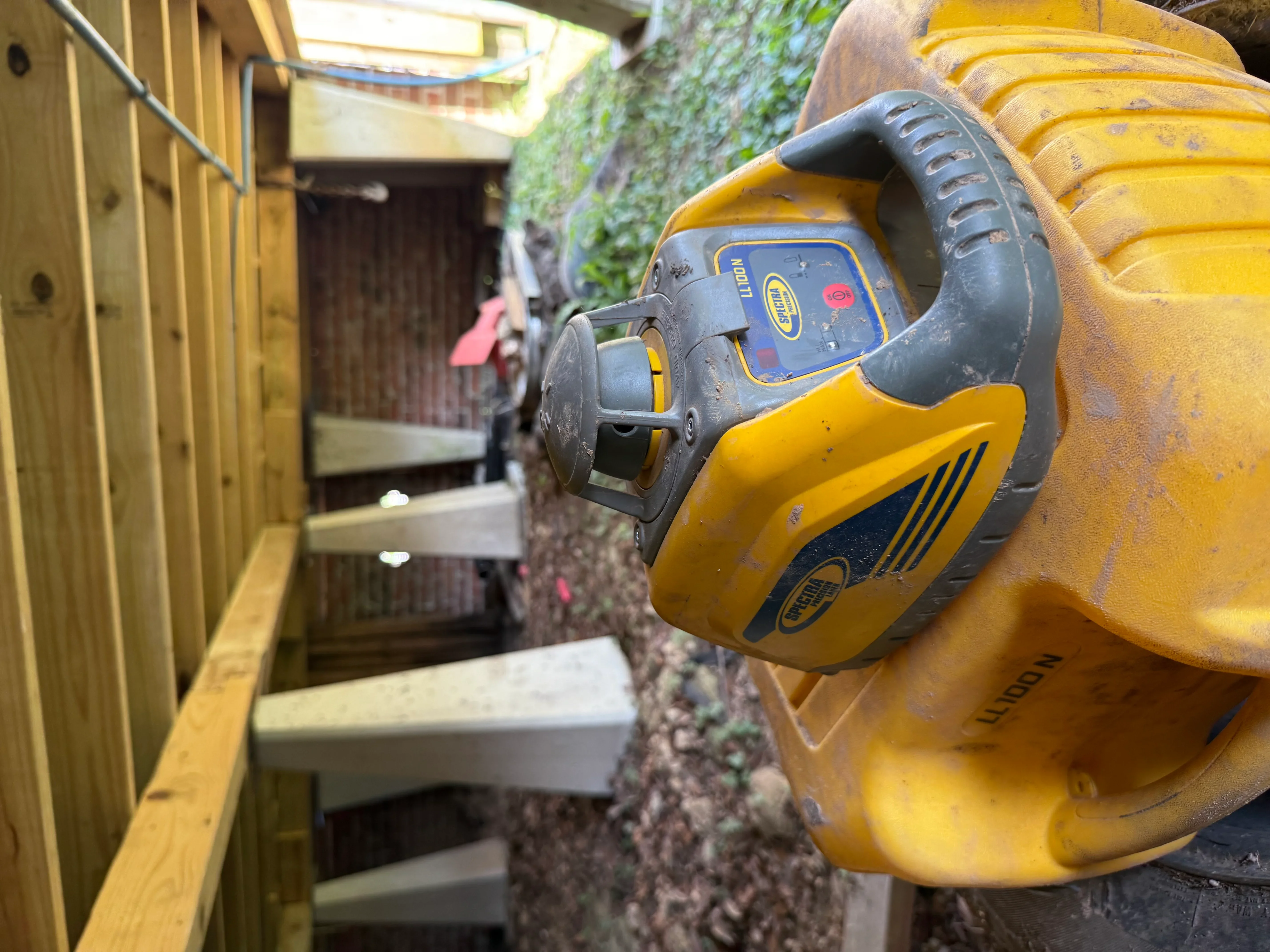 Digital level tool measuring foundation alignment on brick wall