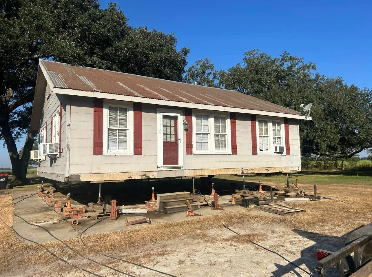 Historic Creole cottage elevated on new foundation pilings during repair work